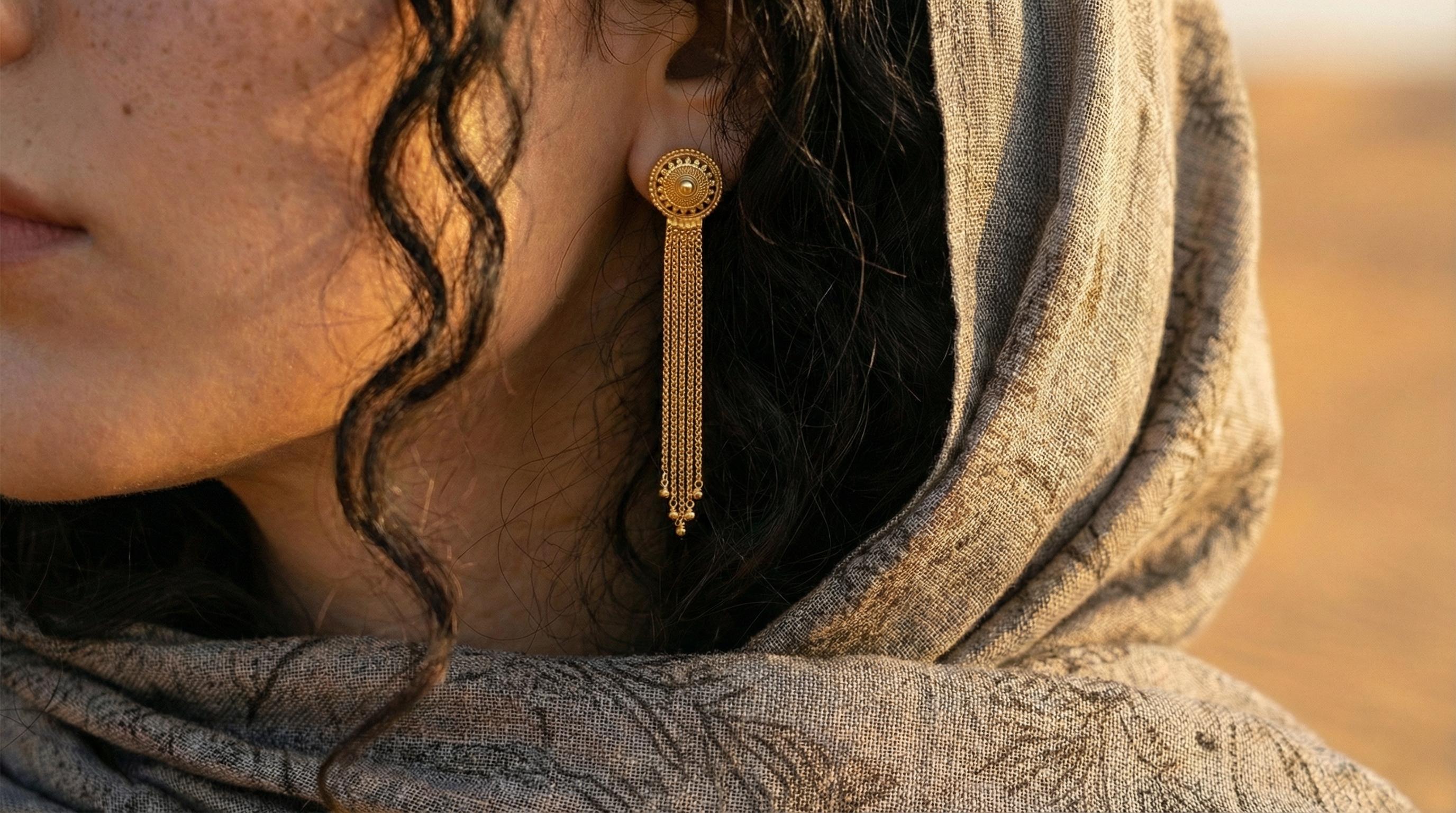 Gulf Heritage editorial — woman with gold jewelry under warm desert light