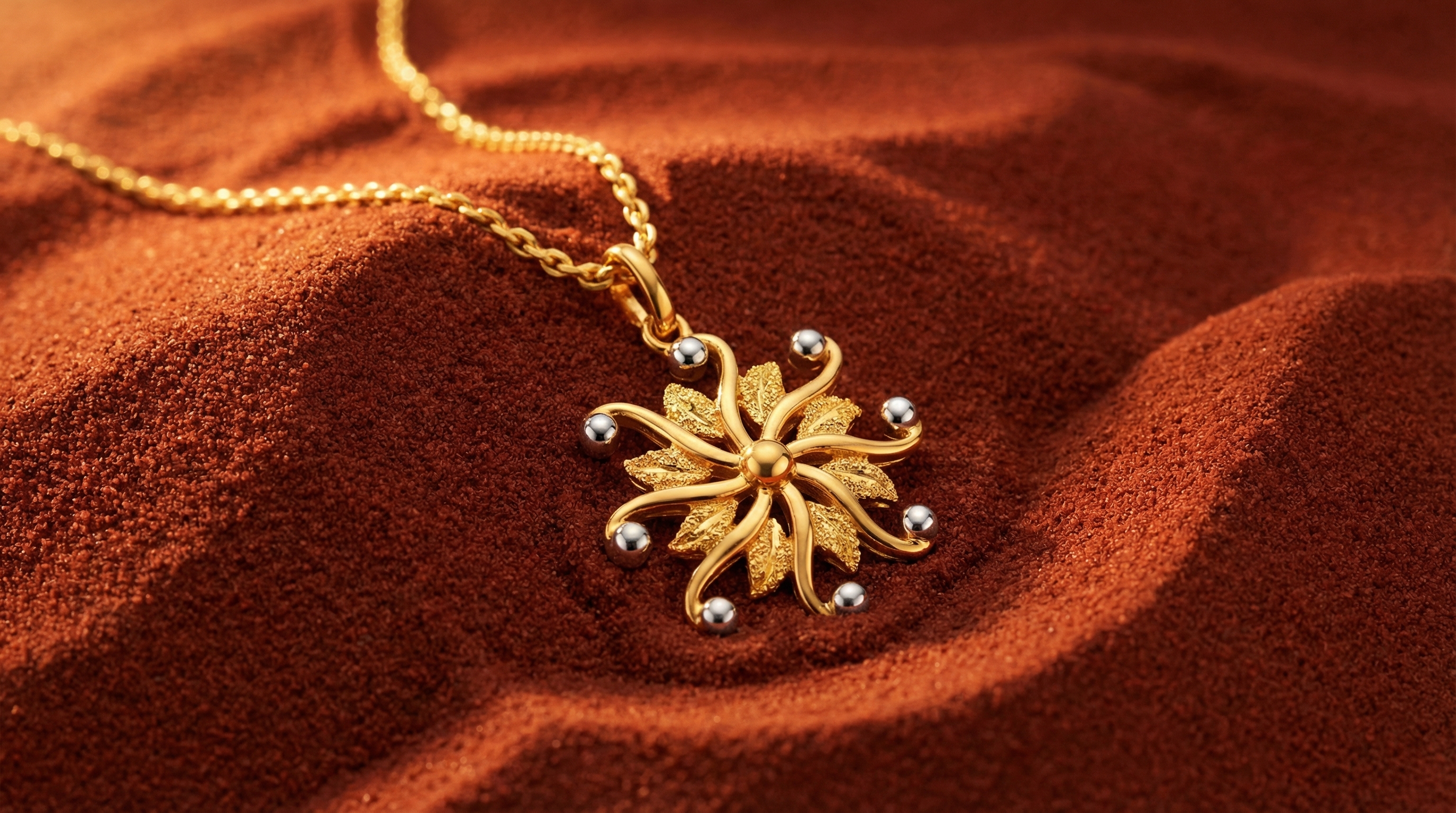 Luxury gold filigree earrings on deep red sand — product campaign